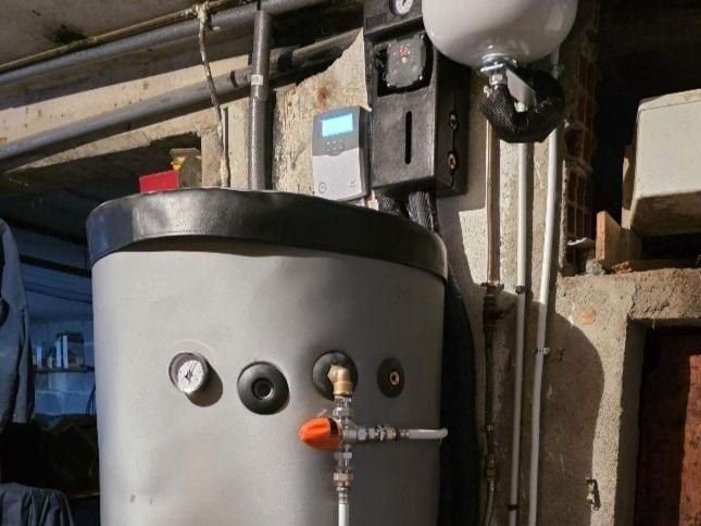Haut d’un ballon d’eau chaude solaire de 300 litres, avec sa régulation et sa station solaire, dans un local technique en Charente-Maritime