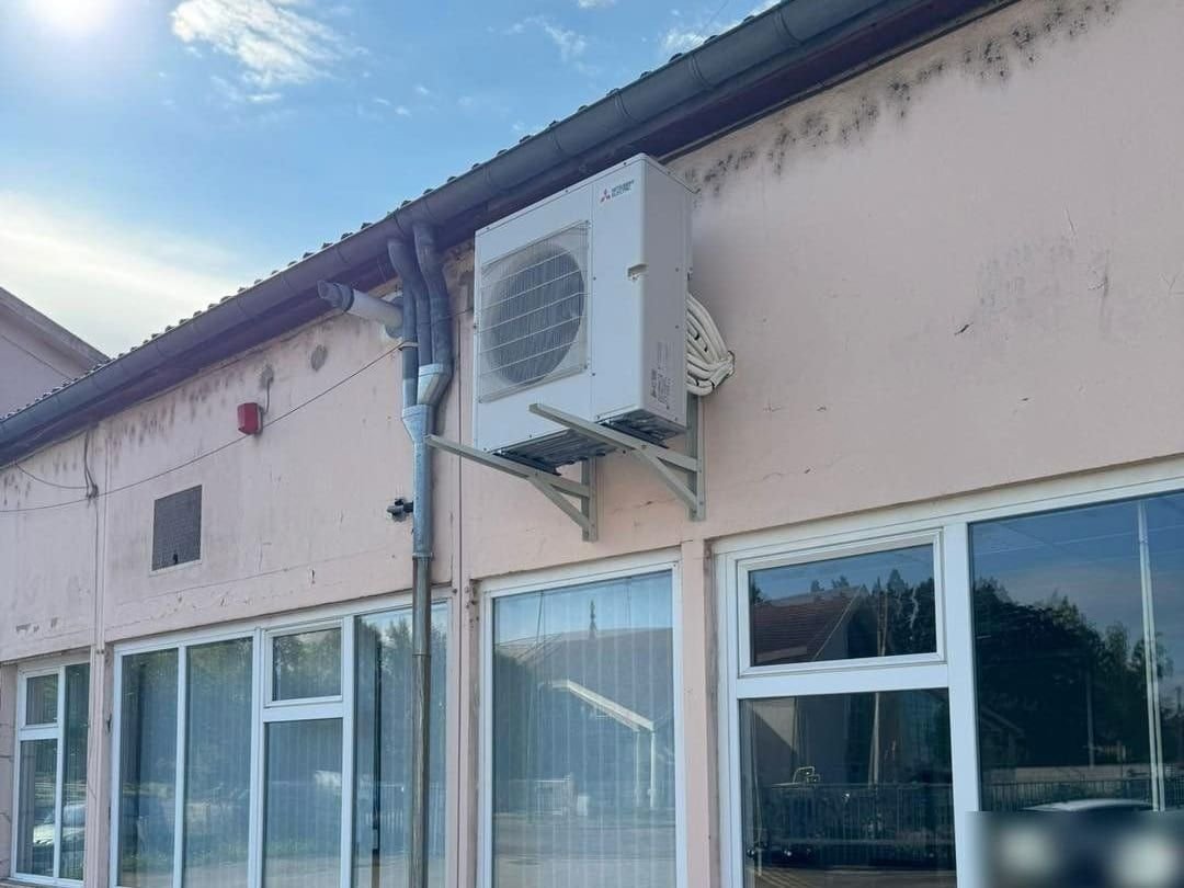 Unité extérieure de pompe à chaleur air/air fixée sur la façade d’un bâtiment de bureaux en Loire-Atlantique