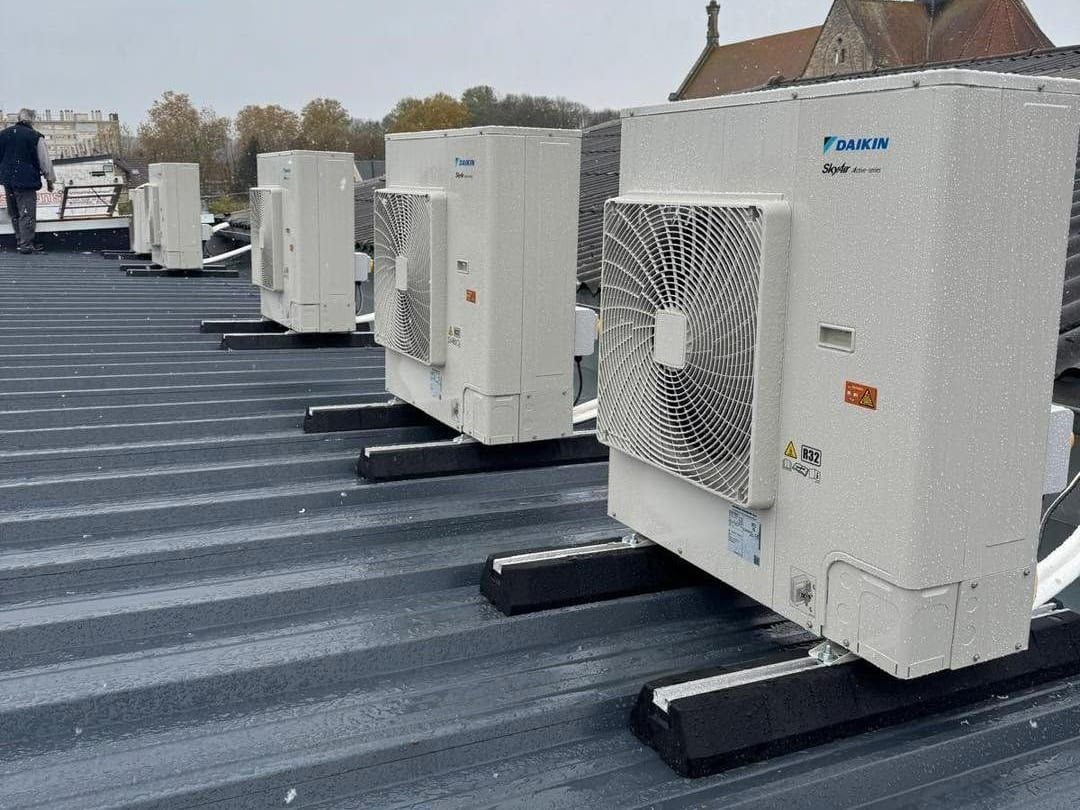 Unités extérieures de climatisation posées sur le toit en bac acier d’un garage automobile